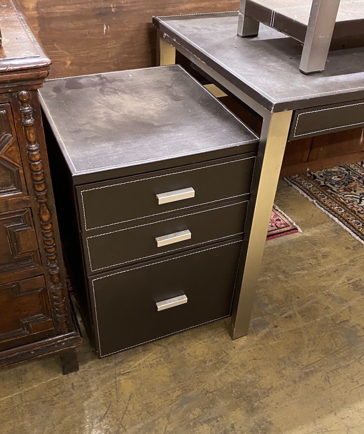 A leather topped and steel writing table, width 120cm, with matching three drawer chest, width 40cm and side table, width 92cm